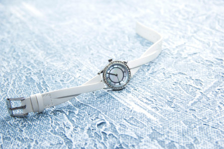 Womens watches with a white strap lie on a gray background.