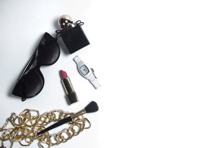 Womens accessories in black and cosmetics on a white background. Top view of the desktop for women