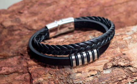 Mens leather bracelet on a wooden background. Black leather bracelet close-upの写真素材