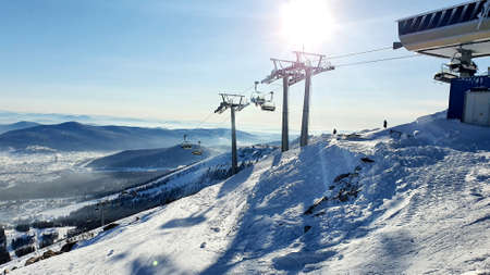chairlifts at the top of a snowy mountainの写真素材