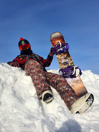 A man with a snowboard in a snowdrift.の写真素材