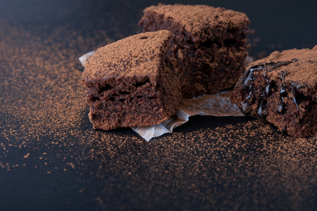 Homemade brownies on dark moody background. Chocolate cake closeup. Copy space.の写真素材