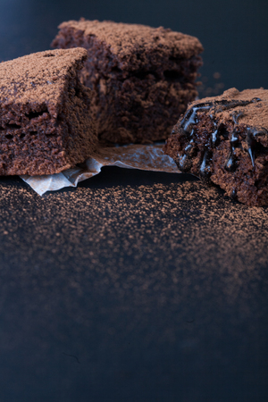 Homemade brownies on dark moody background. Chocolate cake closeup. Copy space.の写真素材