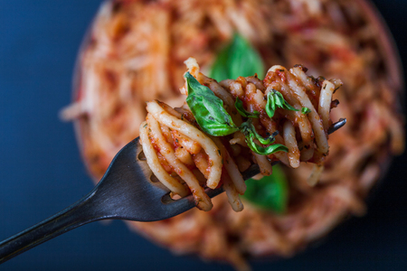 Italian spaghetti with a bolognese tomato meat sauce and basil in a plate. Copy space. Italian food concept.の写真素材