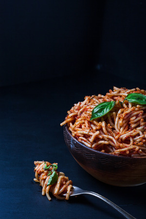 Italian spaghetti with a bolognese tomato meat sauce and basil in a plate. Copy space. Italian food concept.の写真素材