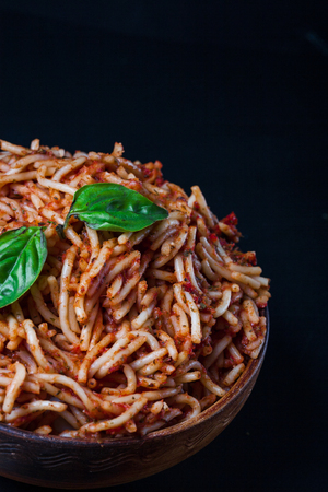 Italian spaghetti with a bolognese tomato meat sauce and basil in a plate. Copy space. Italian food concept.の写真素材