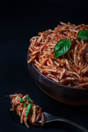 Italian spaghetti with a bolognese tomato meat sauce and basil in a plate. Copy space. Italian food concept.の写真素材