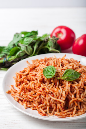 Italian spaghetti with a bolognese tomato meat sauce and basil in a plate. Copy space. Italian food concept.の写真素材