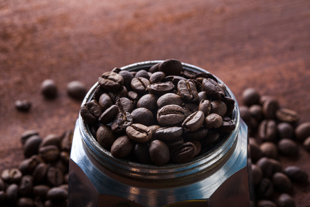 Photo closeup of coffee beans in Aluminium Espresso Coffee Maker. Rusty background. Copy space.の写真素材