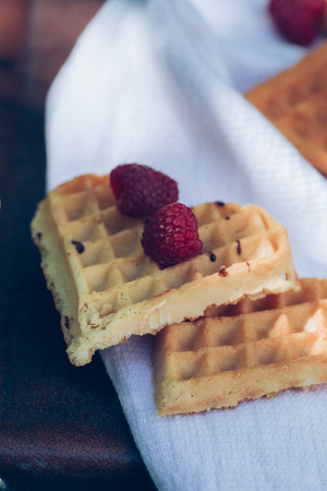 Sweet heart shaped waffles with raspberries for dessert outdoor picnic in the garden.の写真素材