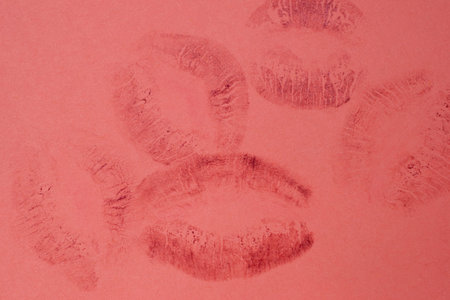 Lipstick kiss marks on a red background, closeup of photoの写真素材