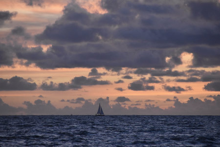 Sailboat on the sea at sunset with clouds in the skyの写真素材