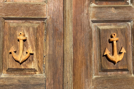 Old wooden door with two anchor on it in the shape of a heart
