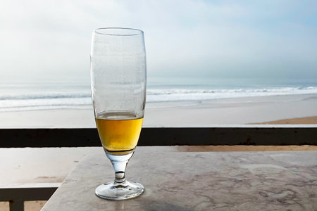 Wineglass on the beach with sea in the background and copy spaceの写真素材