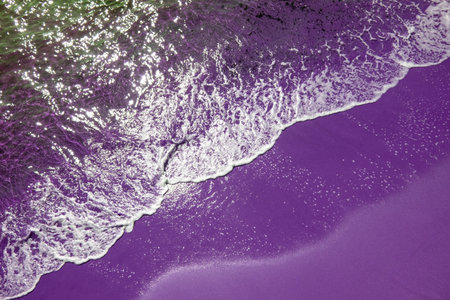 Aerial view of a purple sand beach with waves breaking on itの写真素材