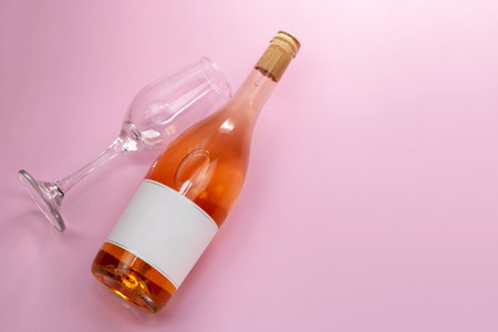 Bottle of white wine with empty label and glasses on pink backgroundの写真素材