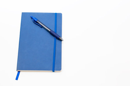 Blue notebook and pen isolated on white background - soft focus with vintage film filterの写真素材