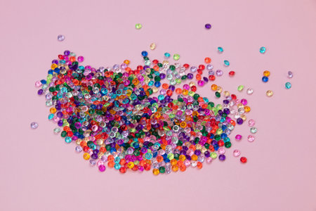 Colorful beads on pink background. Flat lay, top view.の写真素材