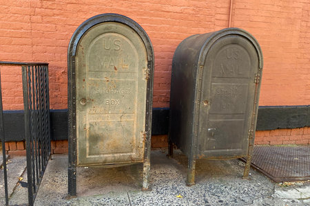 Two old rusty metal mailboxes on a street in London, UK