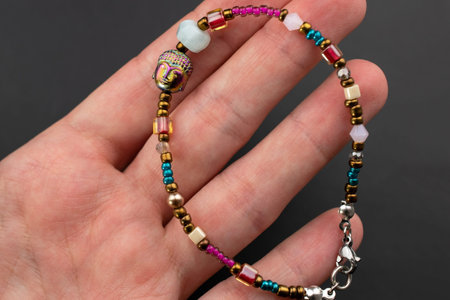 Beaded bracelet in hand on a black background close-up