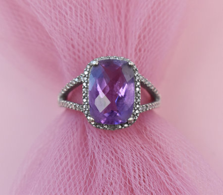 Jewelry ring with amethyst on pink fabric background close upの写真素材