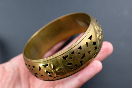 Gold bracelet in hand on a dark background close-up.の写真素材