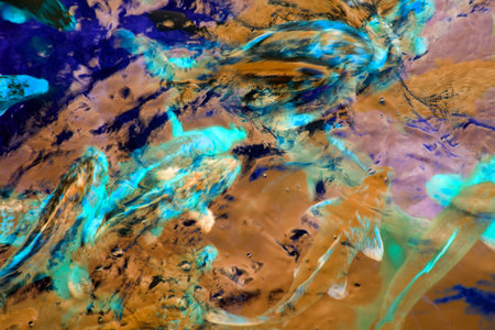 Abstract background of oil paints in blue, yellow and purple tones.