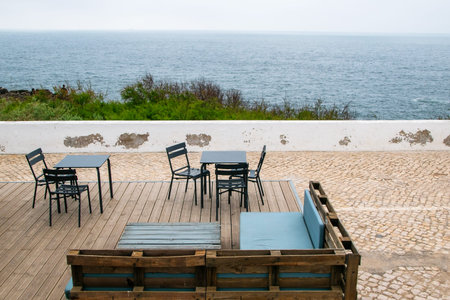Table and chairs on the terrace of a restaurant overlooking the sea