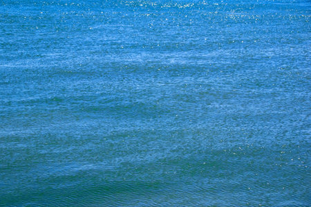 Blue sea water background. Water surface with ripples and waves.の写真素材