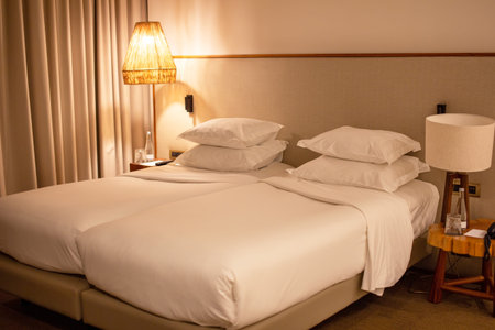 Interior of a hotel bedroom with two white pillows on the bedの写真素材