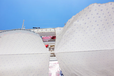 Clothes drying on a clothesline in the sun, closeup of photoの写真素材