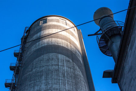 A vertical shot of a silo with blue sky in the backgroundの写真素材