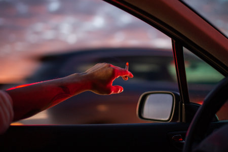 Hand of man driving a car at night with red light on the windshieldのeditorial素材