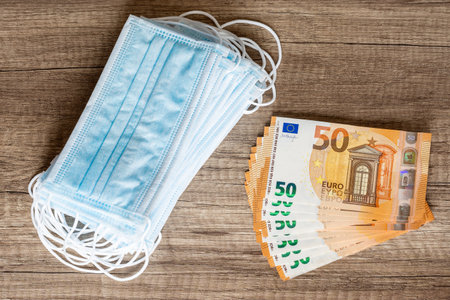 Surgical masks and euro banknotes. Cost of masks.の写真素材