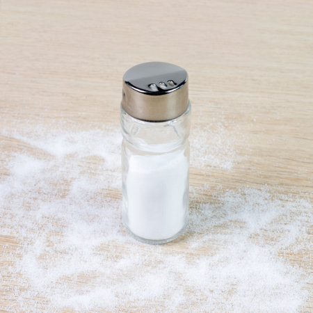 Salt shaker on a pine table. Square photoの写真素材