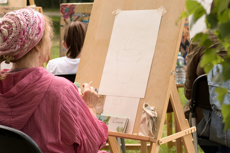Moscow - June 1, 2019: Senior woman draws sketch at art school studio. Topic for art school,...