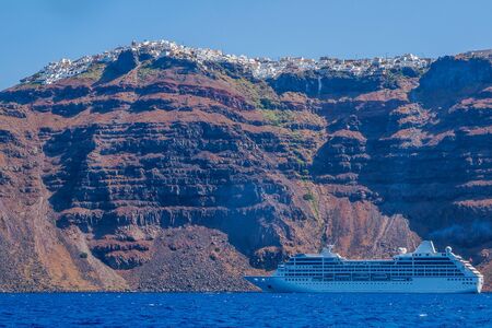 Ship sea trip. Santorini, Cyclades, Greece. Amazing Santorini view on white cave houses from the Aegean sea. Santorini, Cyclades, Greece.の写真素材