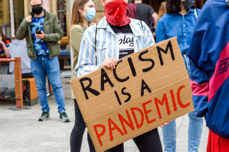 Wroclaw, Poland, 06.06.2020 - Young people hold a poster with words "Racism is a pandemic" on polish peaceful protest against racism and hatred in Wroclaw city.のeditorial素材