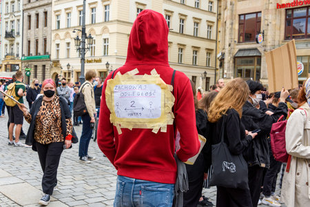 Wroclaw, Poland, 06.06.2020 - Young man with words on his back about keep distance two meters, social distance on polish peaceful protest against racism and hatred in Wroclaw city.のeditorial素材