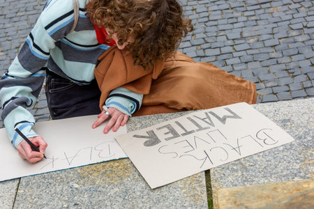 Wroclaw, Poland, 06.06.2020 - Young girl write a poster for protest with words black lives matter on...
