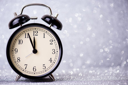 Alarm clock on a silver glitter background