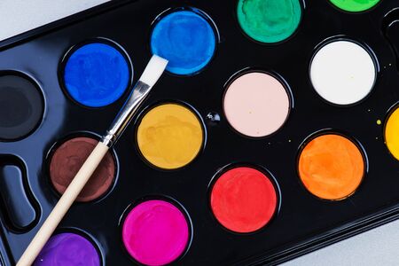 Set of watercolor paints and a paintbrushの写真素材