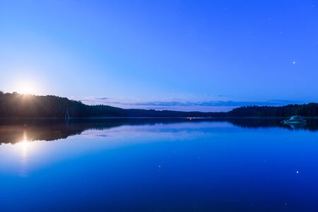 Beautiful night lake landscape. Calm lake like a mirrorの写真素材