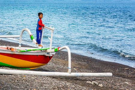 BALI, INDONESIA - November 29, 2019: Life in a fishing village, little boy in a spiderman costume on...