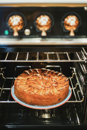Apple pie baking in oven. Traditional French apple pie in the oven.