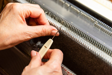 Woman working with hands on home knitting machine. Small Business
