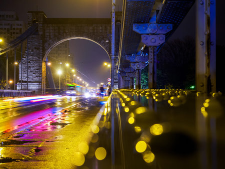 night urban scene, transport driving thru a suspension bridge.