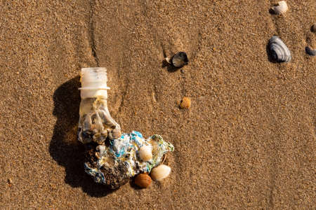 Sea plastic trash. Dissolved plastic bottle on beach throw away by Sea Water. Plastic waste dragged by the sea to a beachの写真素材