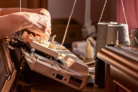 Womans hands working with knitting machine, knitting as womans hobbies. Small Business of Garment...