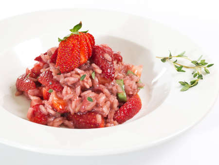 portion of sweet strawberry risotto flavored with rosemary on white plate with copy spaceの写真素材